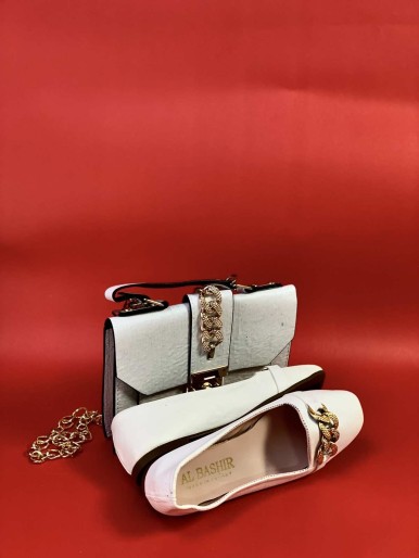 White bag with shoes with golden rings