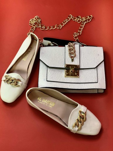 White bag with shoes with golden rings