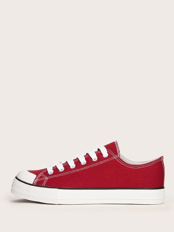 Red sneakers with white soles and laces