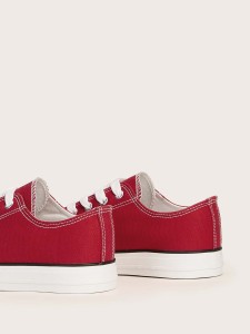 Red sneakers with white soles and laces