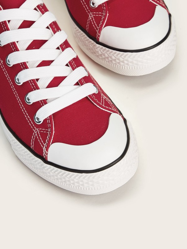 Red sneakers with white soles and laces