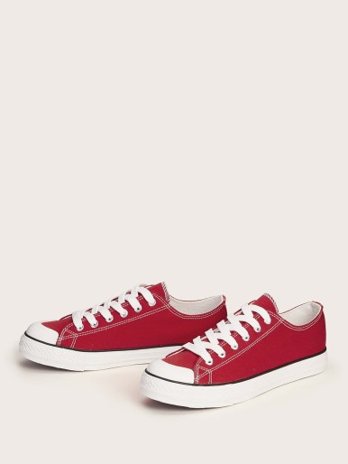 Red sneakers with white soles and laces