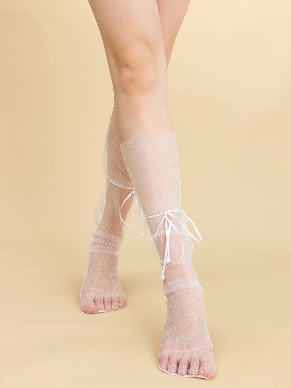 جوارب مزخرفة بعقدة على شكل فيونكة فوق ربلة الساق